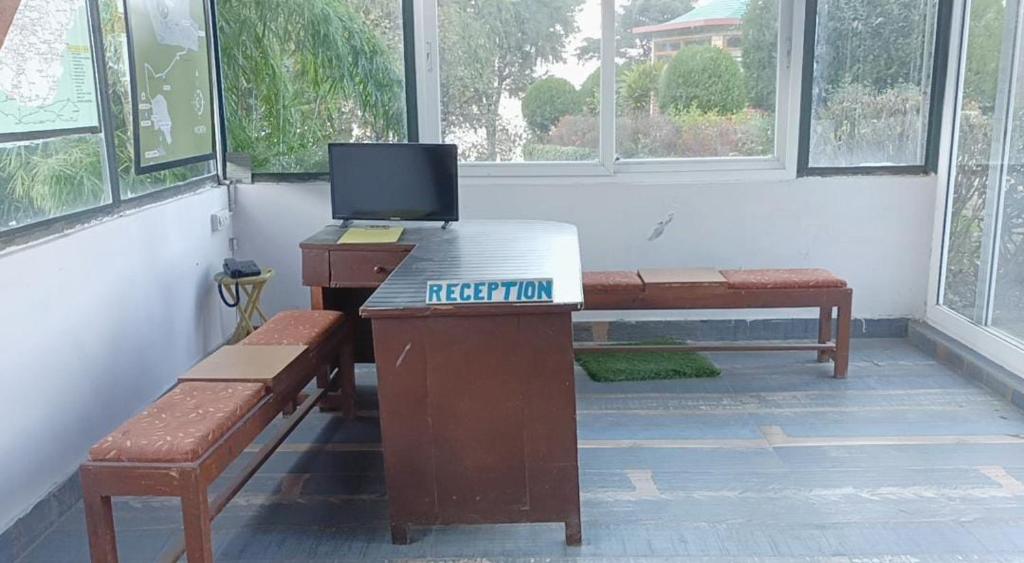 穆索里Himalayas Youth Hostel Kempty Mussoorie的客房设有一张带笔记本电脑的书桌