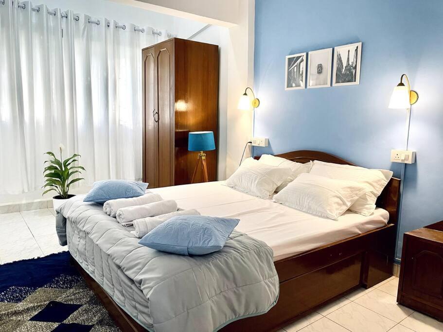 科尔瓦Luxurious 1BHK with a Pool AniRah Homes in Colva的卧室配有一张带白色床单和枕头的大床。