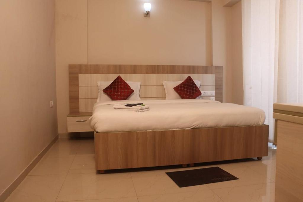 马图拉Hotel Shyam Basera的一间卧室配有一张带红色枕头的大床