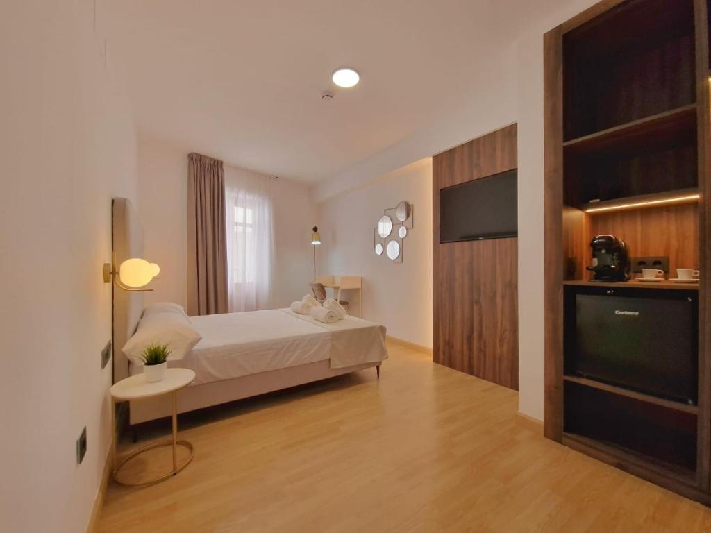 塞埃欣HOSTAL HS CEHEGIN的一间卧室配有一张床和一台平面电视