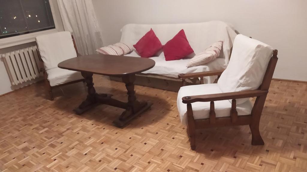 华沙Uroczy apartament z bezpłatnych parkingiem的客厅配有沙发、两把椅子和一张桌子