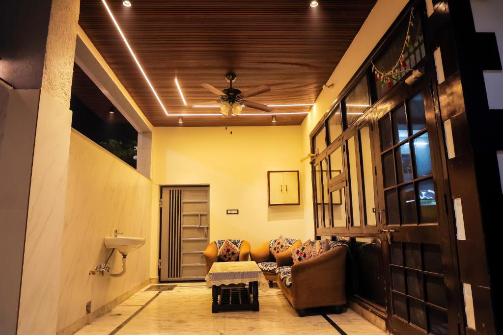 阿格拉Anirudh Homestay的带沙发和吊扇的客厅