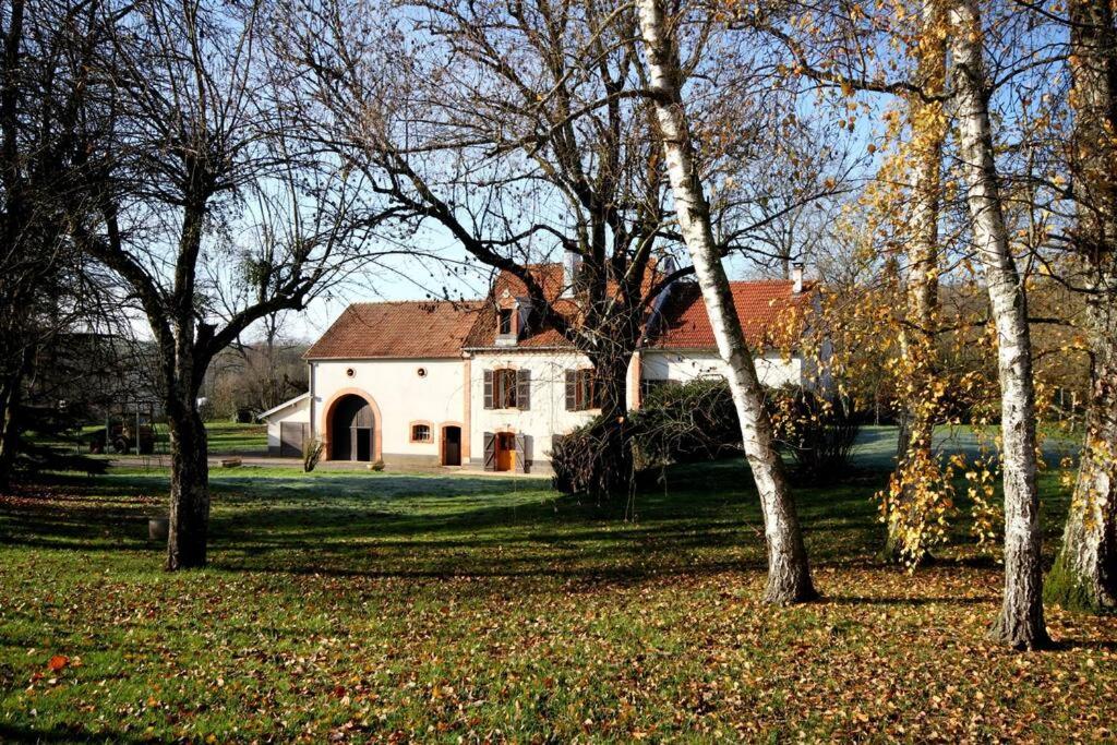 Gîte Au Moulin de Bougnon Calme et Dépaysement en Haute-Saône的一座白色的大房子,有一群树木
