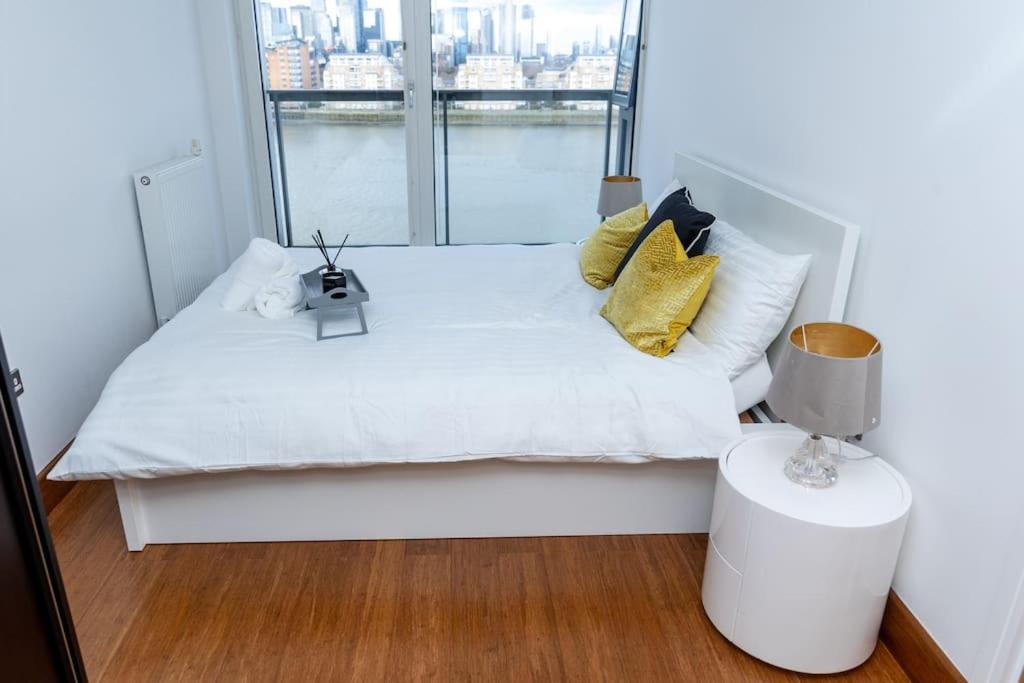 伦敦Luxury 2 bed- 2 bath Riverside Haven的卧室配有白色的床和大窗户