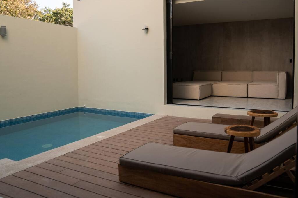 埃斯孔迪多港Casa Amelia Puerto Escondido的一间带游泳池和沙发的客厅