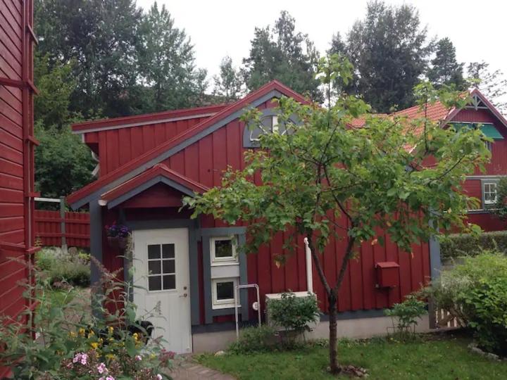 乌普萨拉Lilla Gäststugan的红房子,有白色的门和一棵树