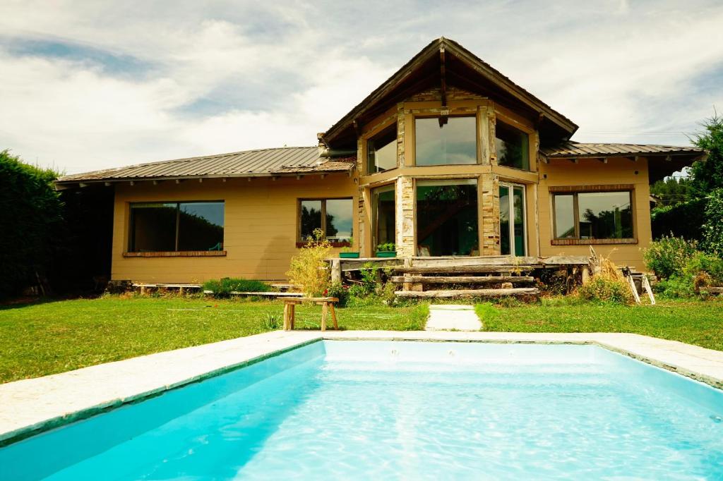 圣卡洛斯-德巴里洛切hermosa casa a una cuadra del lago的房屋前有游泳池的房子