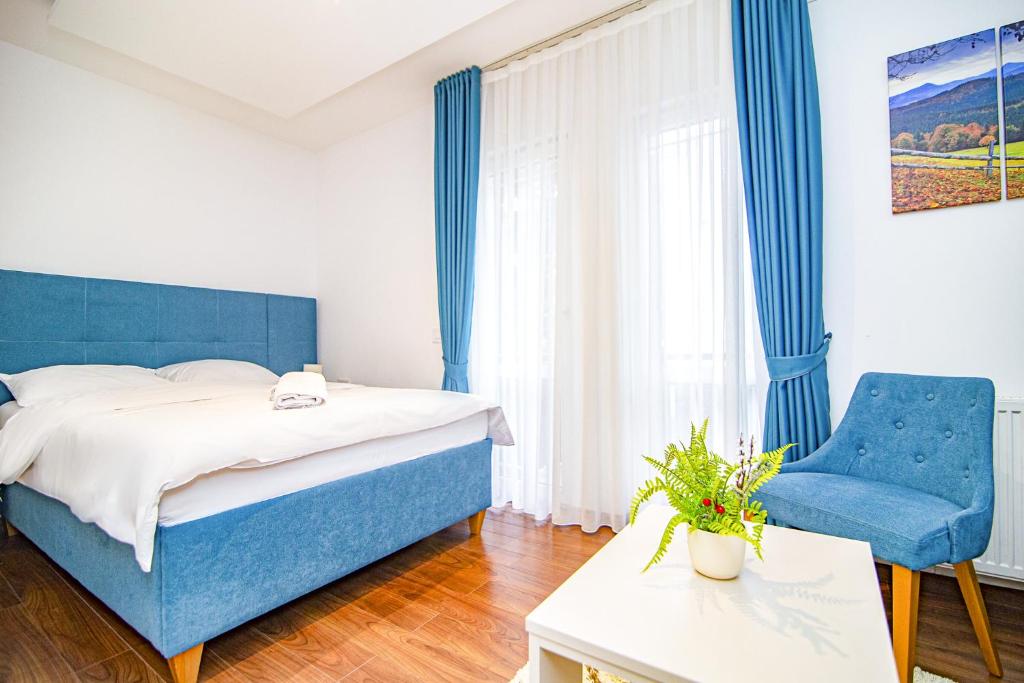 兹拉蒂博尔Hotel Konačište Akustik的一间卧室配有蓝色的床和蓝色椅子