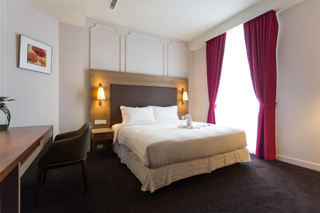 高雄麗馨商旅七賢館的酒店客房设有一张大床、一张书桌和一张书桌。