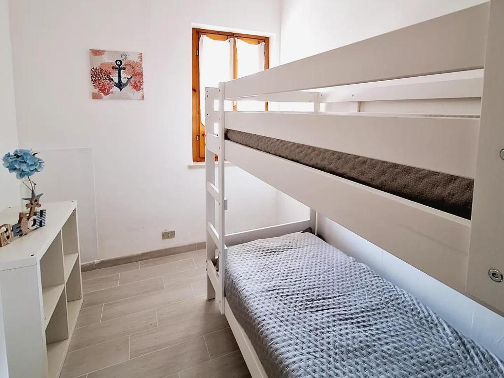 努马纳Conero Casa Vacanze Amelia Garden的白色卧室配有双层床和书桌