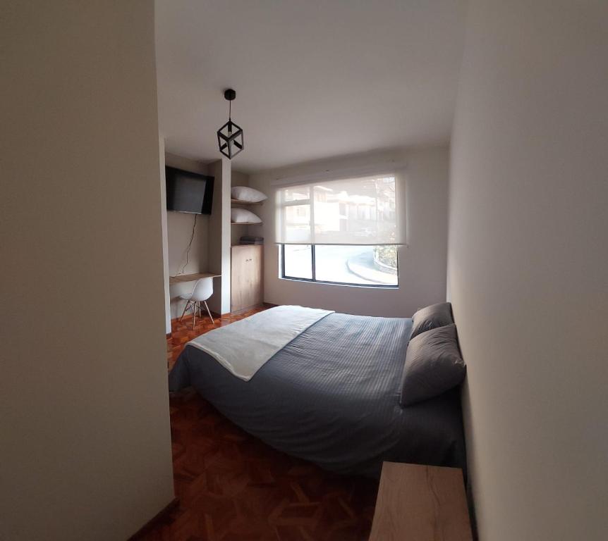 马尼萨莱斯Casa Palermo Manizales的一间卧室设有一张床和一个窗口