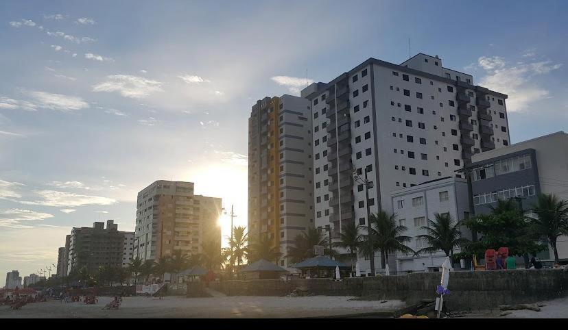 蒙加瓜Apartamento beira mar Centro da cidade WiFi grátis的海滩上一群高大的建筑,日落