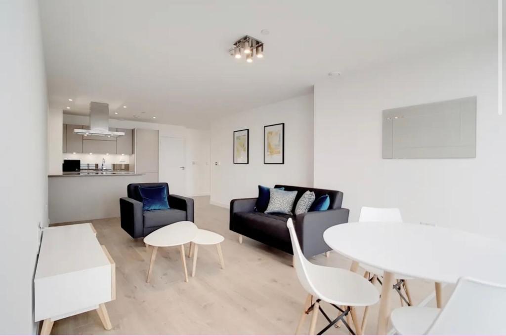 伦敦1 Bedroom Apartment Stratford的客厅配有沙发、椅子和桌子