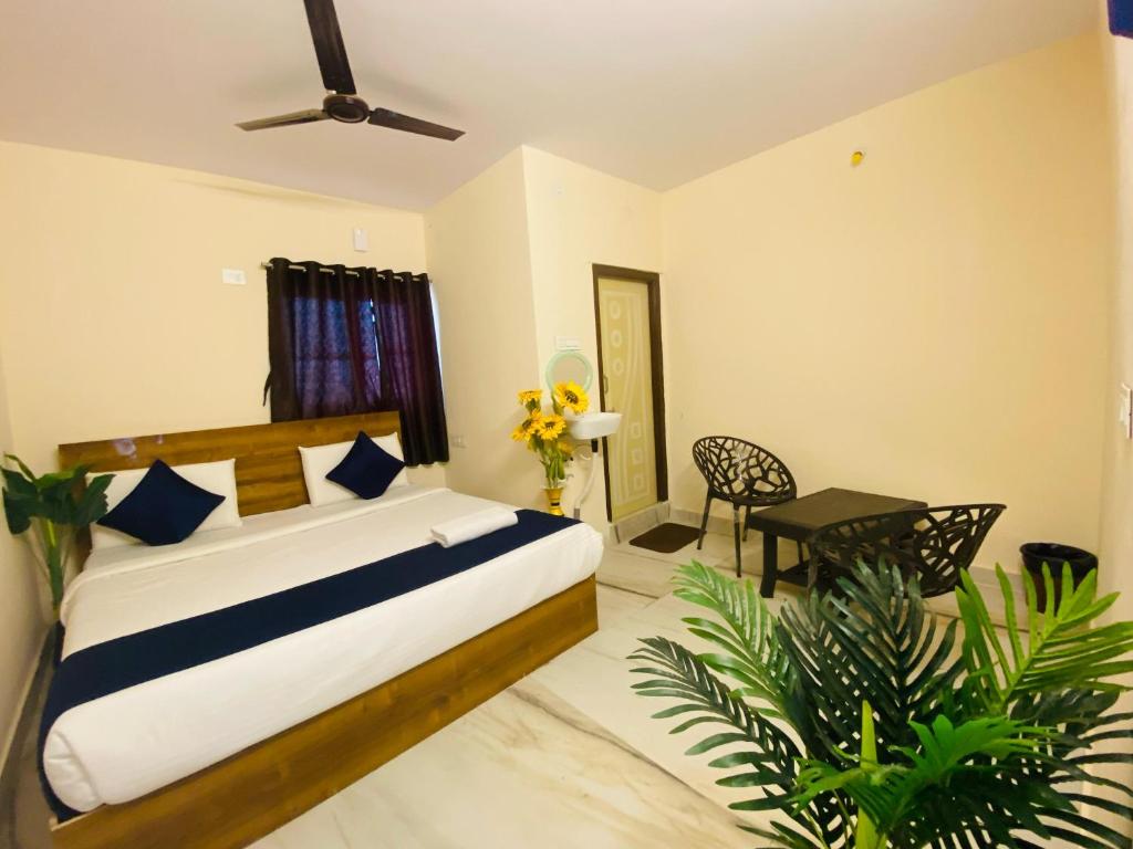 商沙巴Hotel KP Suites Airport的一间卧室,配有一张床铺和一张桌子,还有一些植物