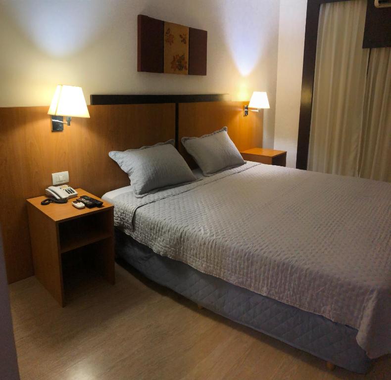 巴西利亚Flat 315 - Comfort Hotel Taguatinga的酒店客房,设有床铺和2个床头柜