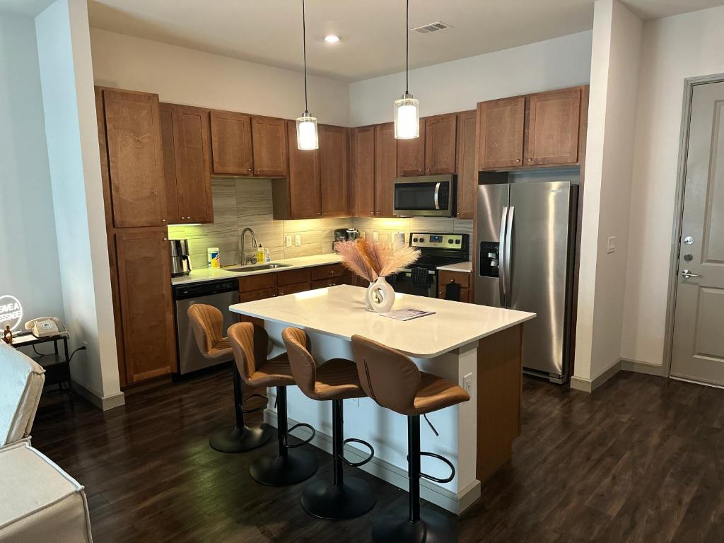 休斯顿Downtown Houston Cozy Queen Suite的厨房配有桌椅和冰箱。
