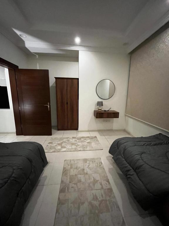 Abḩur al Janūbīyahشقة بغرفتين نوم وصالة بالمحمدية的一间卧室设有两张床,墙上设有一面镜子
