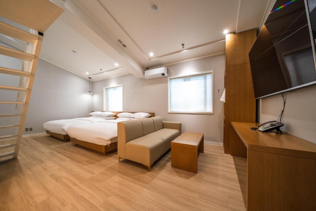 水原市MONO HOTEL的一间卧室配有一张床、一台电视和一张沙发