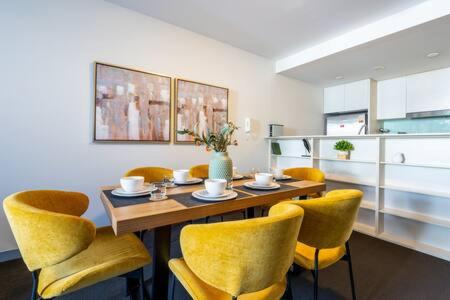 悉尼Sleek Inner-City Getaway in Prime Location的一间带桌子和黄色椅子的用餐室