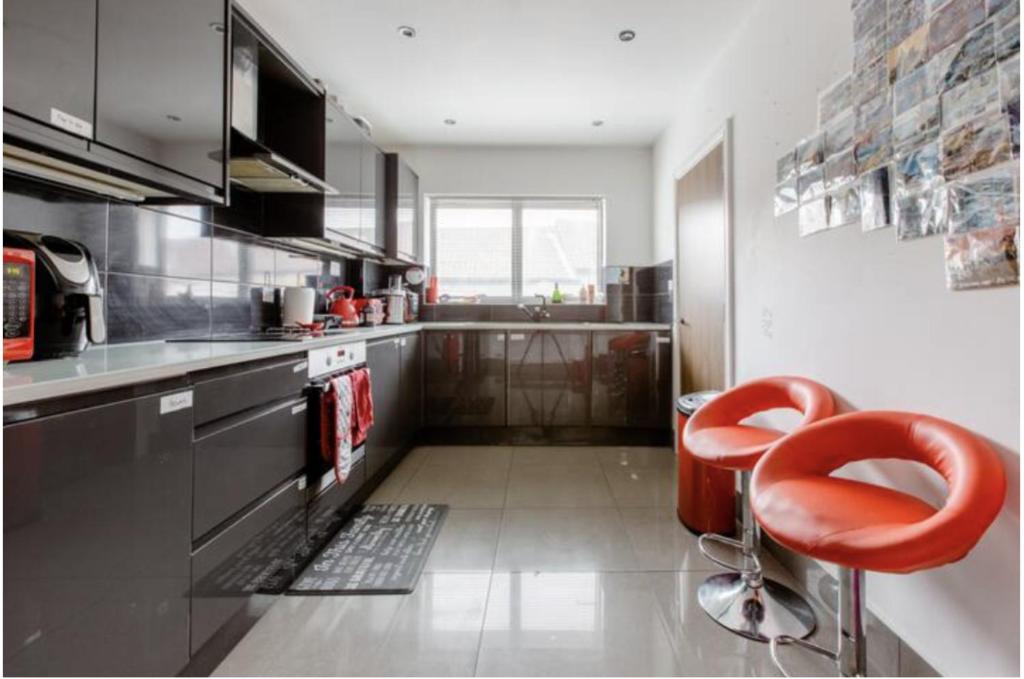 KentChic DuoRooms with Modern Comfort for Families的厨房里设有红色凳子