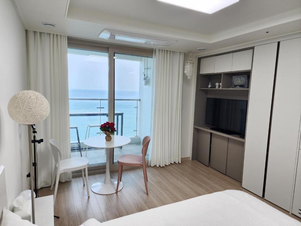 束草市Sokcho Summitbay 1701 "Ocean View"的一间带桌子的卧室和一间享有美景的客房