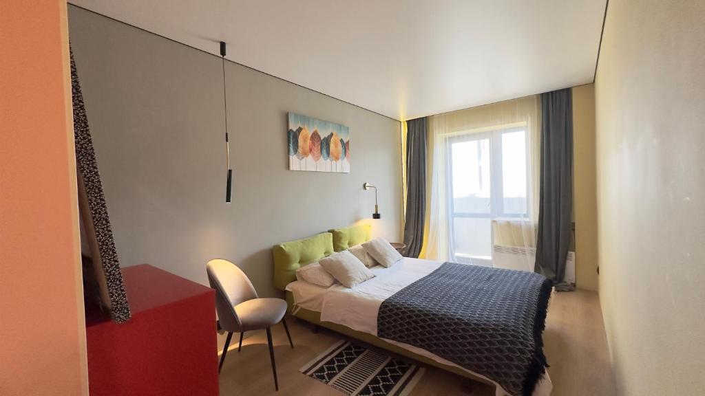 第聂伯罗2 room Modern Apartment的卧室配有床、椅子和窗户。