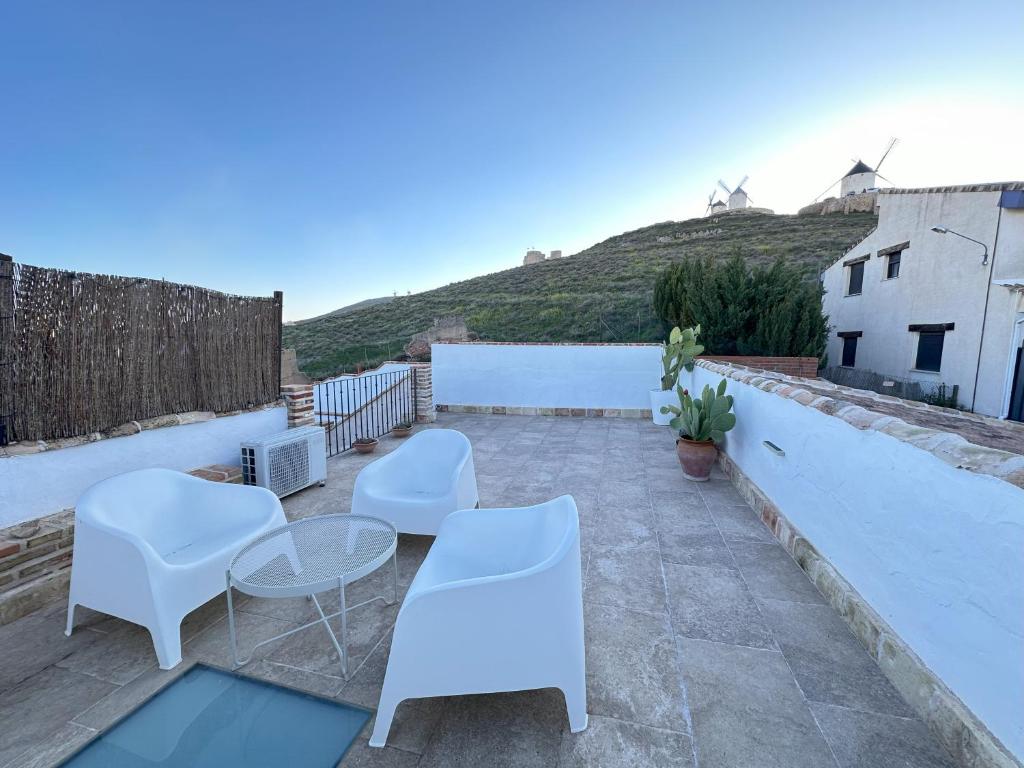 孔苏埃格拉Casa Entre Molinos的屋顶露台配有白色的椅子和桌子