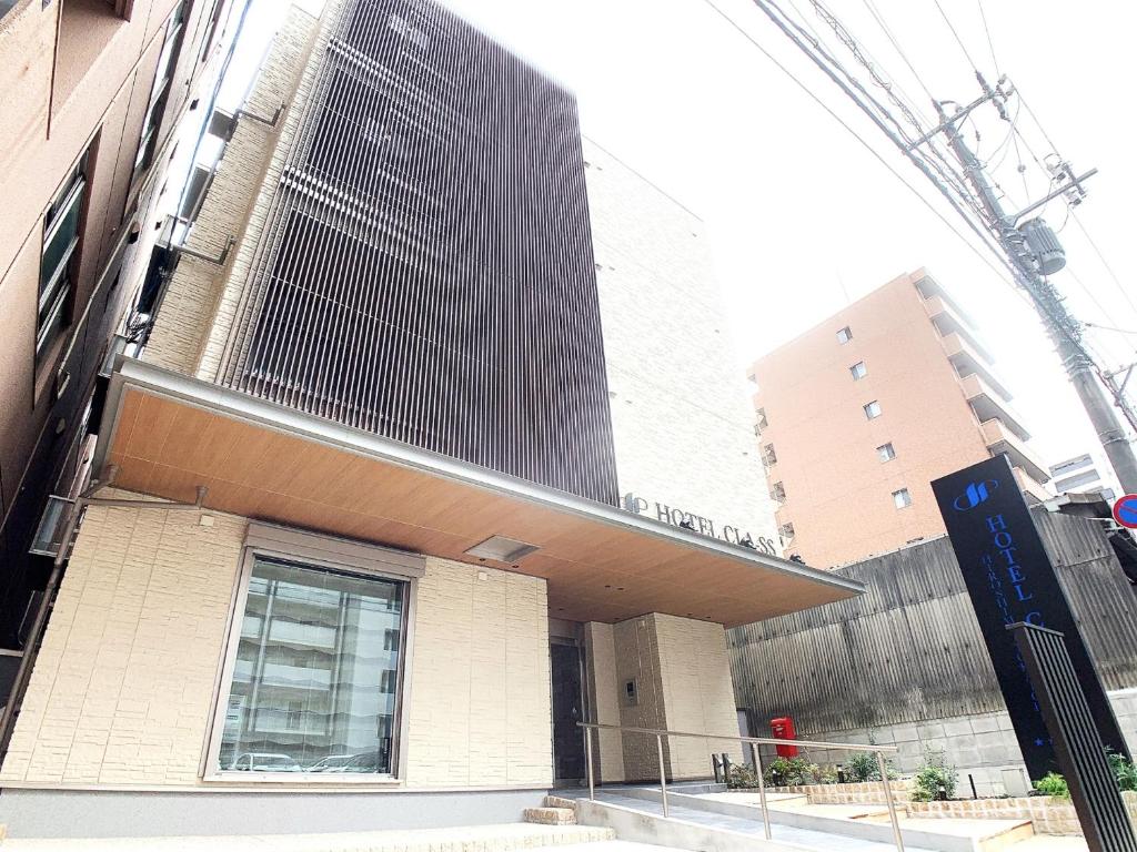 广岛HOTEL CLA-SS HIROSHIMA-TOKAICHI的街道上的建筑,有建筑