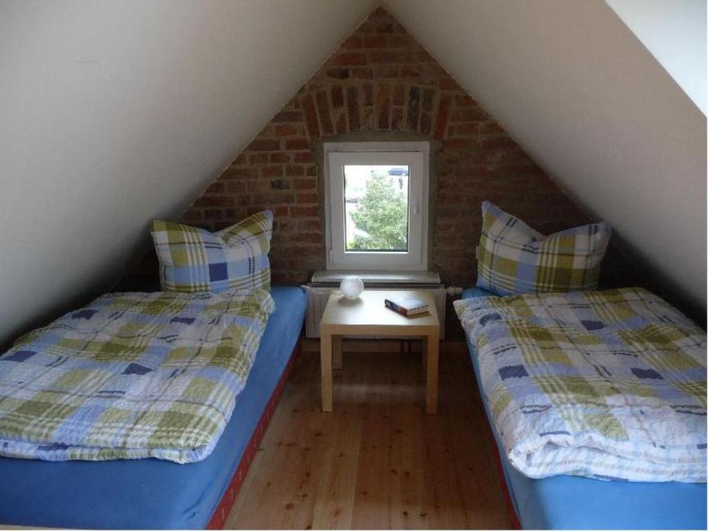 塞巴特阿尔贝克Ferienwohnung Ida的阁楼卧室设有两张床和窗户。