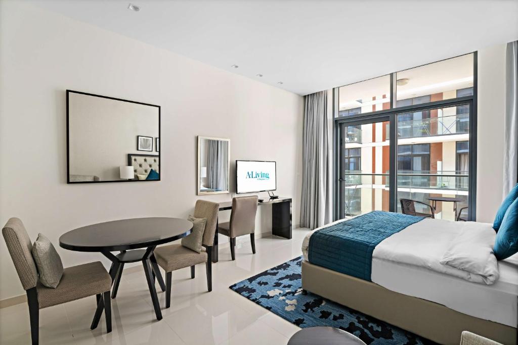 迪拜Aliving Elite Studio Celestia A Dubai South的卧室配有一张床和一张桌子及椅子