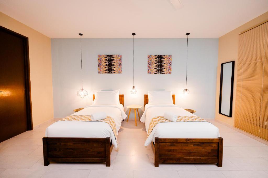 瓜埠Rebungan Resort Langkawi的一间卧室配有两张床和一张桌子