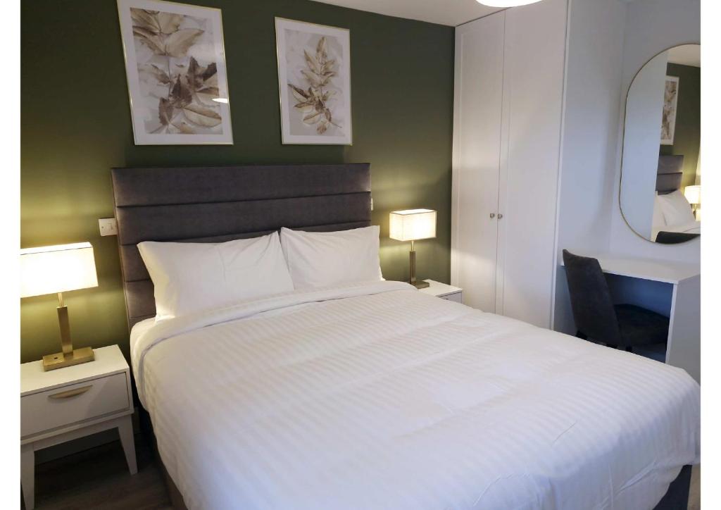 斯莱戈Station Lodge的卧室配有一张白色大床和两盏灯。