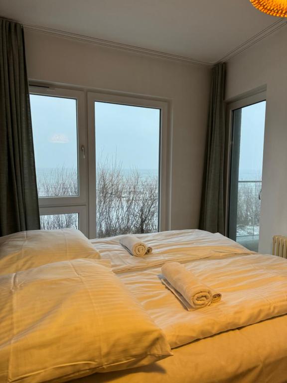 梅尔诺Apartament przy plaży 9的窗户间内的一张带两条毛巾的床
