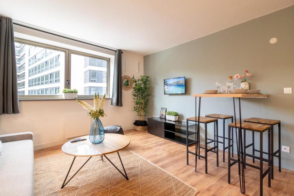 里尔Lille Grand Place - 1 bedroom apartment的客厅配有一张桌子和两张凳子