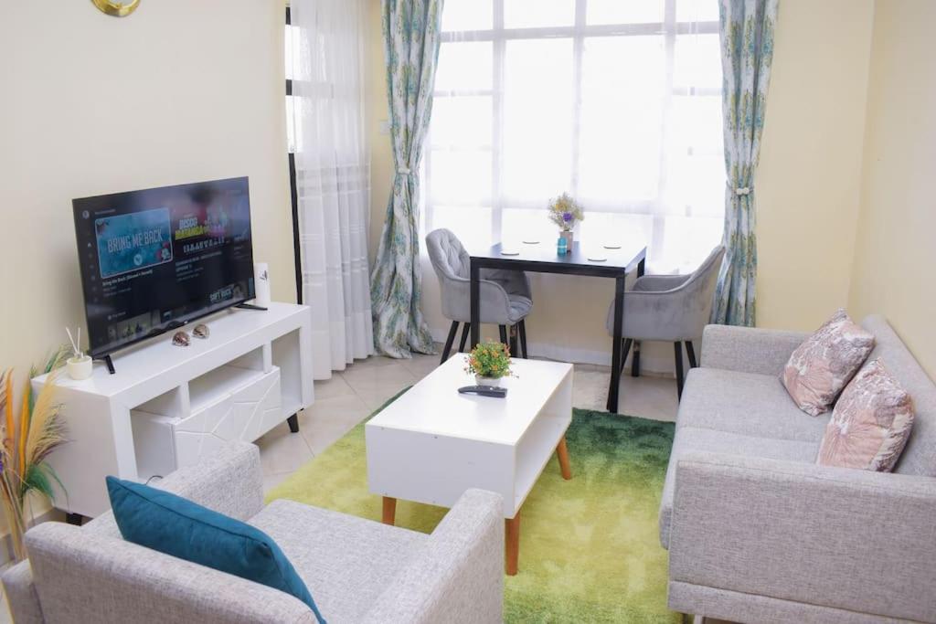 MeruMarvel Homes的带沙发、电视和桌子的客厅