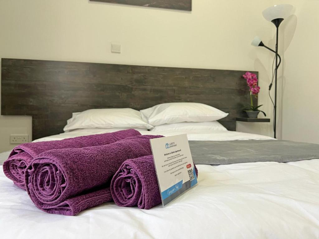 拉纳卡Apollo Rooms by Albert's Apartment的床上一堆紫色毛巾