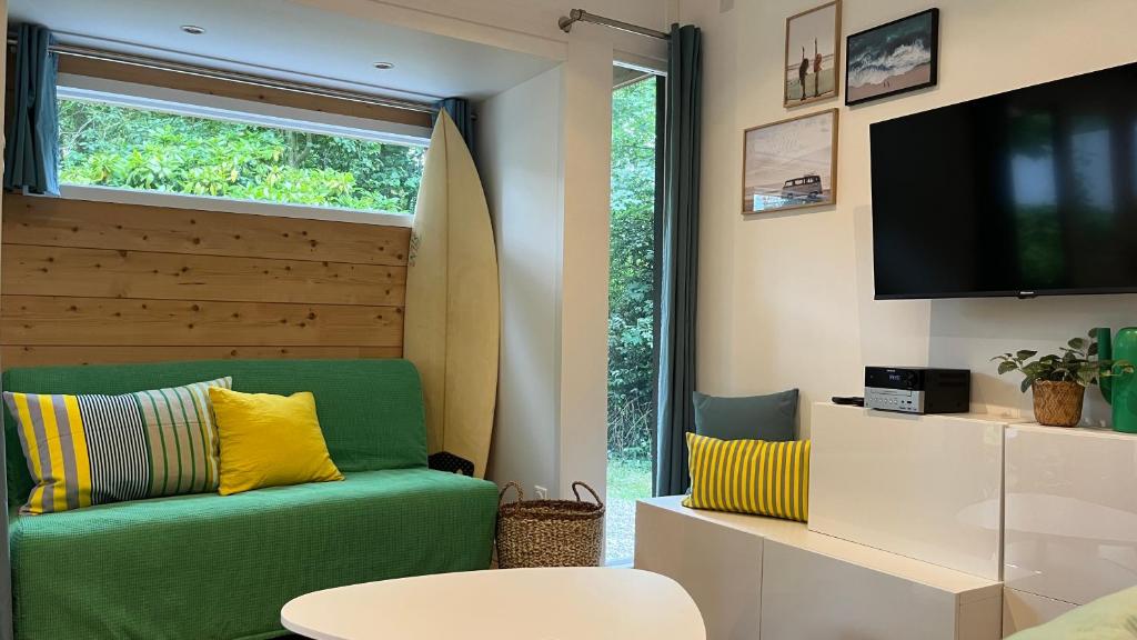 Bonningues-lès-CalaisLe Bungalow的客厅配有绿色沙发和电视