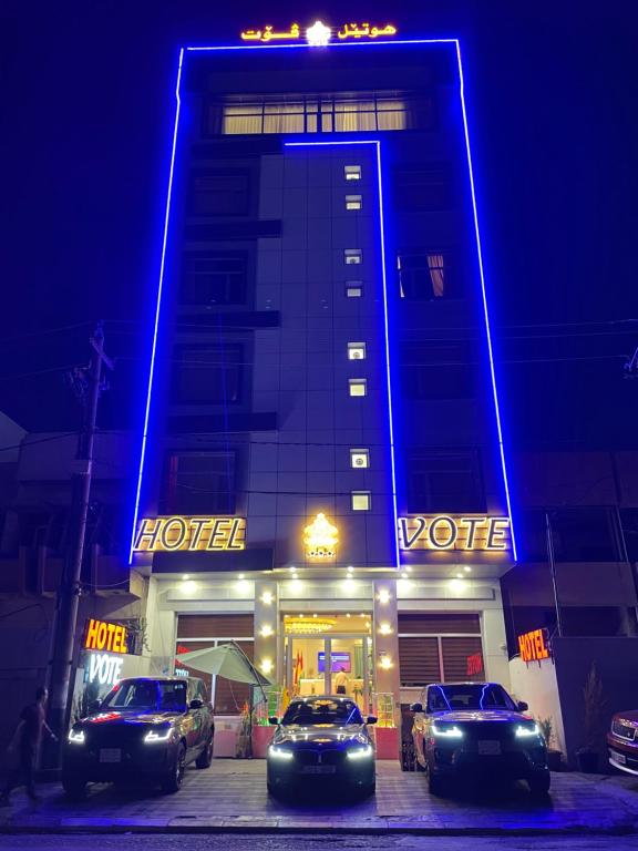 埃尔比勒Vote Hotel的一家晚上停在酒店前面的汽车酒店