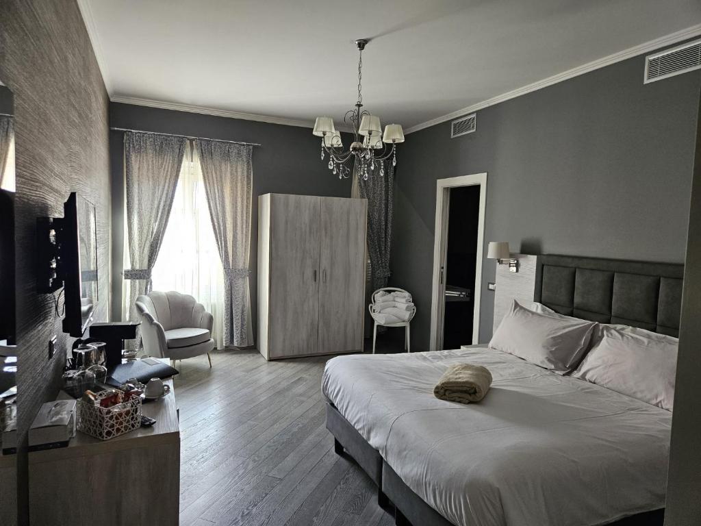 圣雷莫Primafila Premium Guest House的一间卧室配有一张床,另一间卧室配有椅子