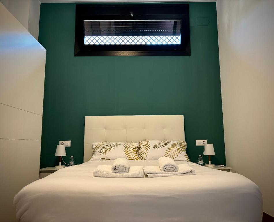 科尔多瓦Tabor的一间卧室配有一张白色的床和绿色的墙壁