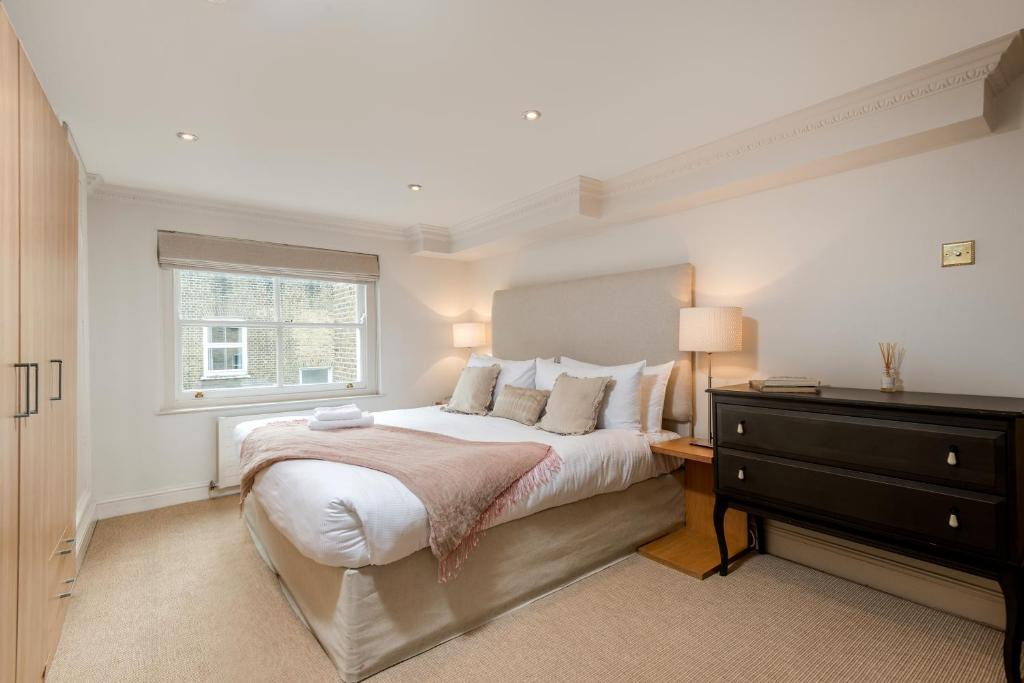 伦敦Spacious, Calm One Bedroom的一间卧室配有带梳妆台和窗户的床。