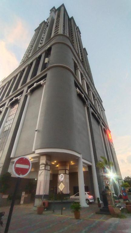 哥打巴鲁Cmk APARTMEN KOTA SRI MUTIARA# Free Netflix的一座高大的灰色建筑,上面有停车标志