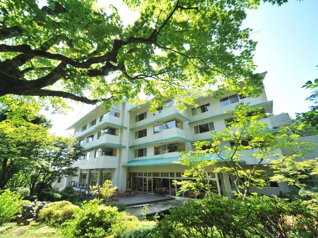 阿贺野长生馆酒店的前面有树木的白色建筑