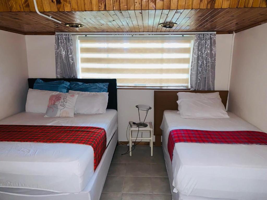 约翰内斯堡Naisiae - Lovely 1-bedroom vacation home with pool的小型客房 - 带2张床和窗户