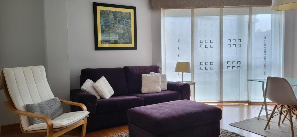 拉科鲁尼亚Apartamento en Coruña con parking的客厅配有紫色沙发和椅子