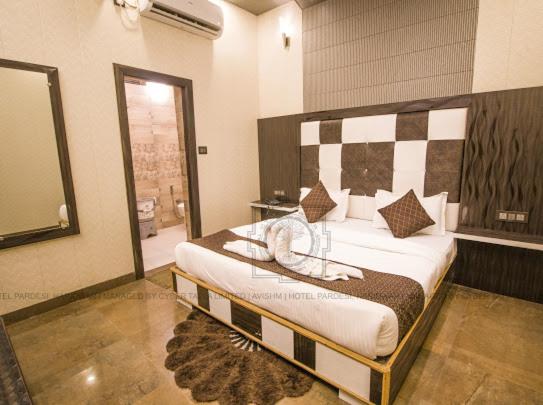 哈里瓦Hotel Paradesi and Restaurant AJ Group的一间卧室配有一张大床和床头板