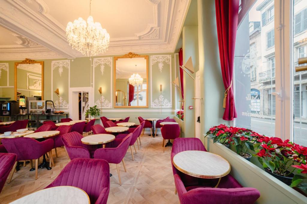 莫尔莱Grand Hôtel de l'Europe的餐厅设有紫色桌椅和吊灯