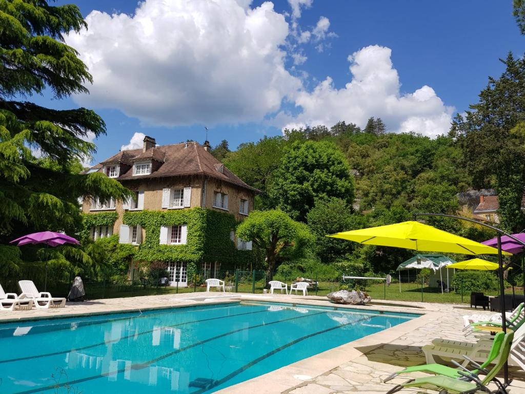 莱塞齐耶德泰阿克梅内斯特尔住宿加早餐酒店的房屋前的游泳池配有椅子和遮阳伞