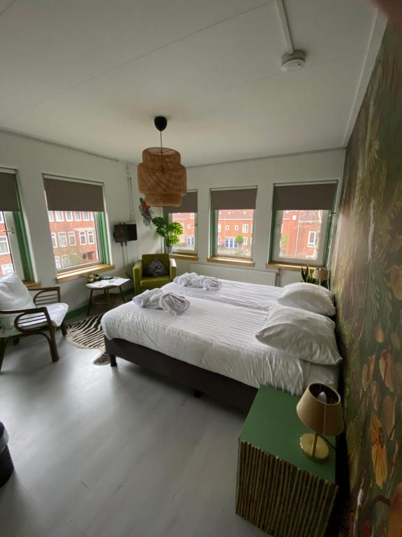 格罗宁根思迪因斯塔德酒店的一间卧室设有一张大床,部分设有窗户。