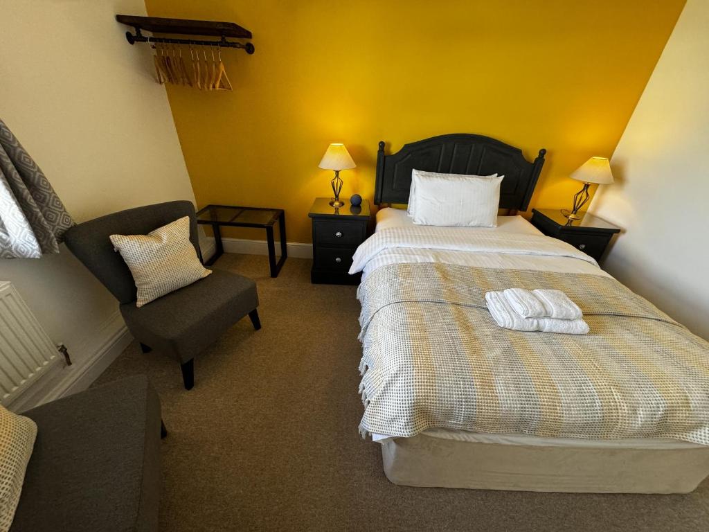 查尔德Watermead House的配有一张床和一把椅子的酒店客房
